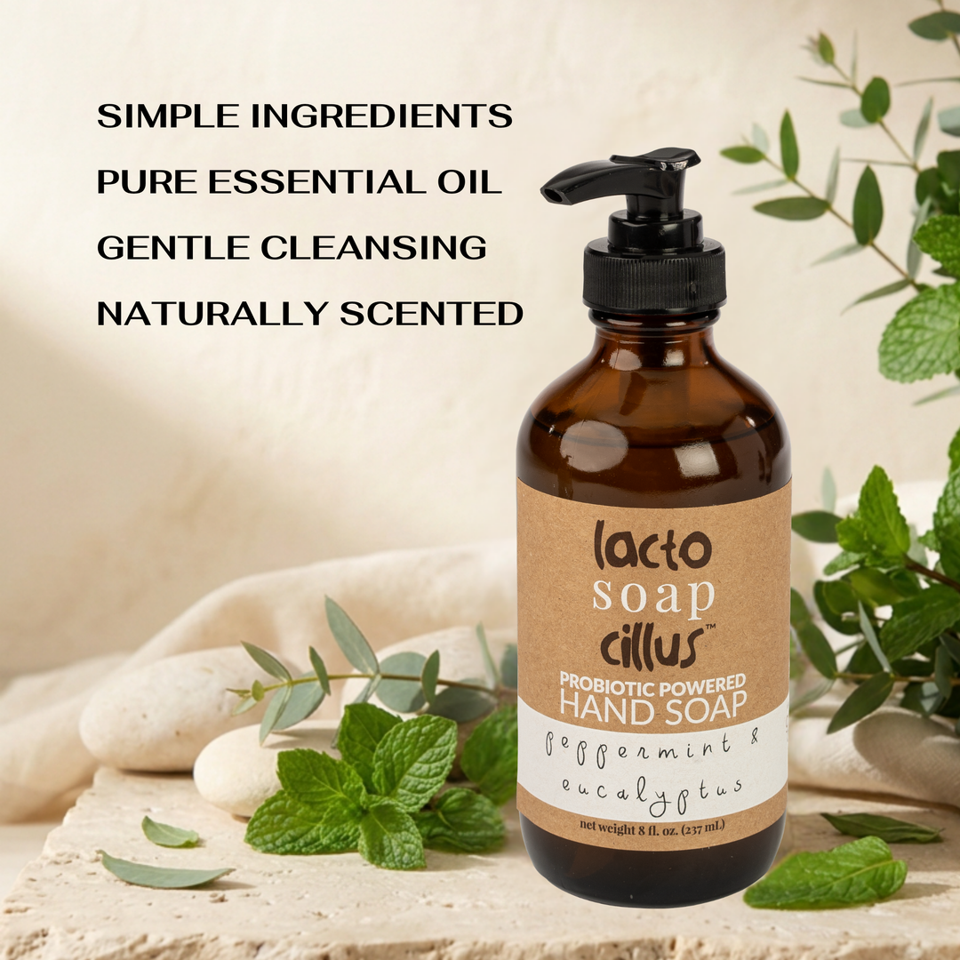 Lacto Soap Cillus hand soap bottle with natural ingredients text and green leaves on a stone surface.